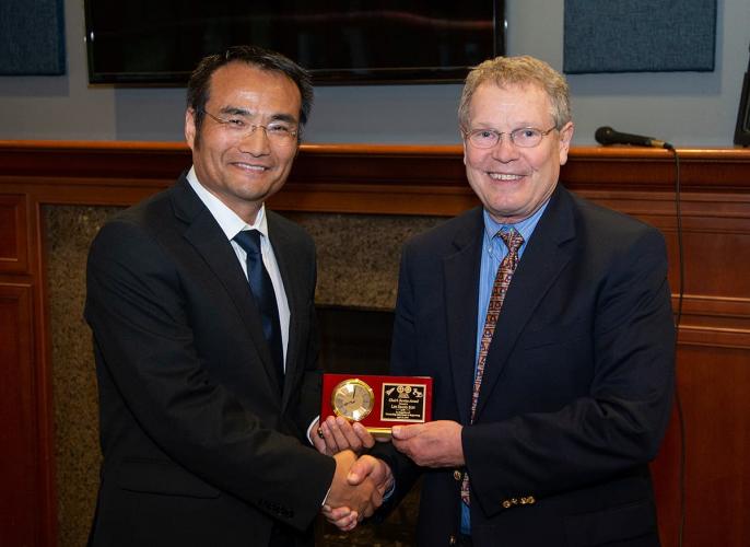 Eric Hellstrom, Ph.D. (right) gives Lin Xiang Sun (left) a Distinguished Alumni Award during the 2019 Department of Mechanical Engineering Alumni Awards Banquet.