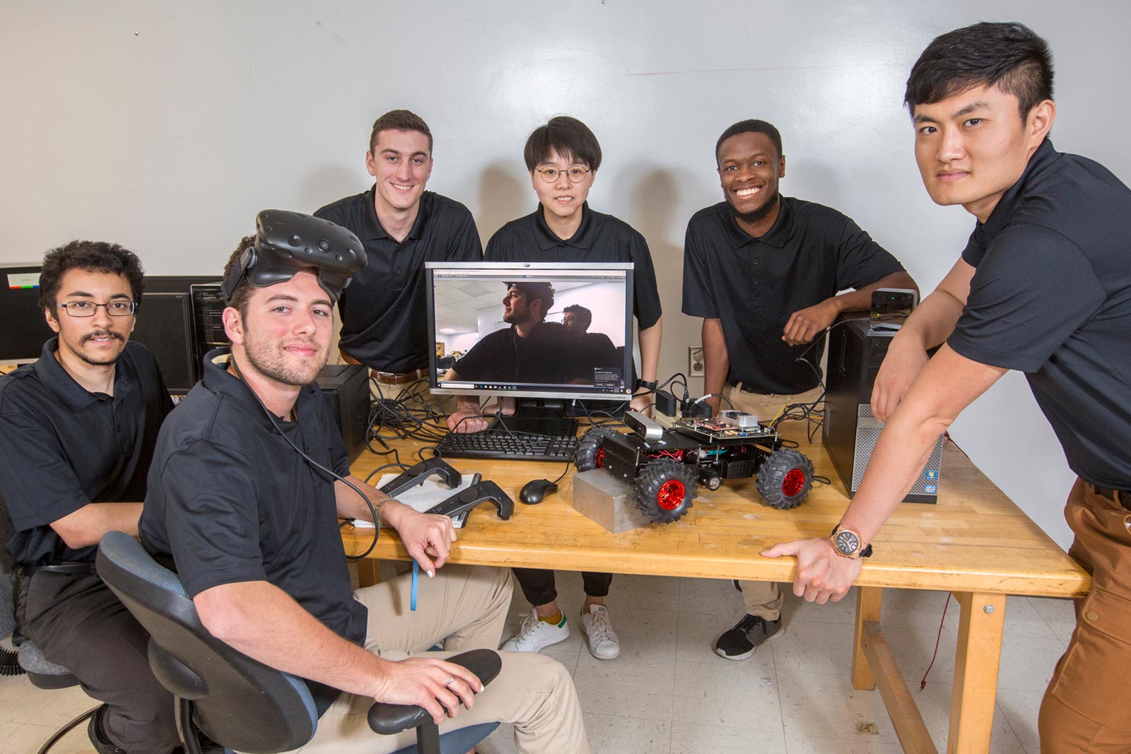 Group of undergraduate male students displaying their senior design projects