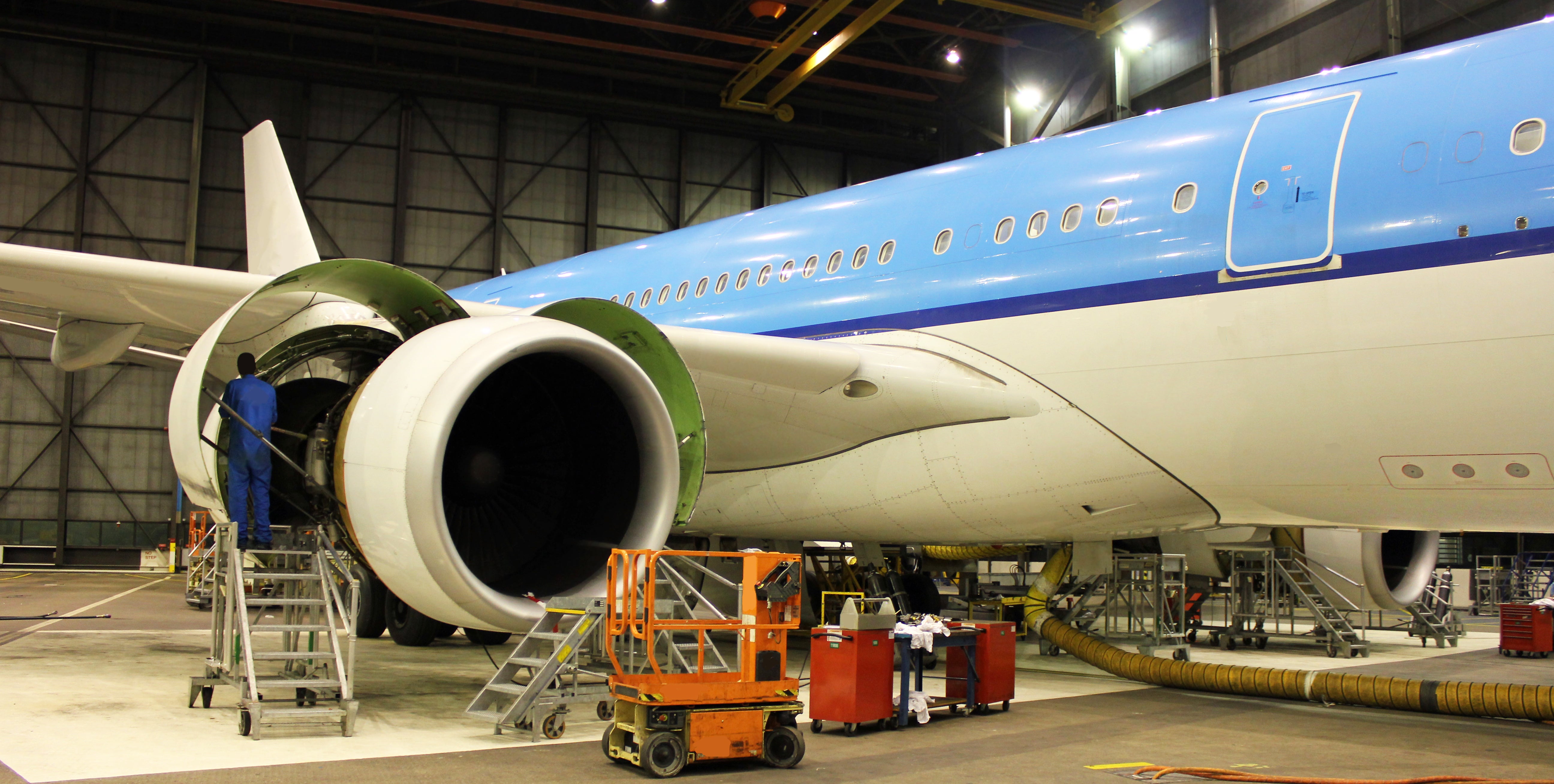 Employee working on exterior of Boeing plane.