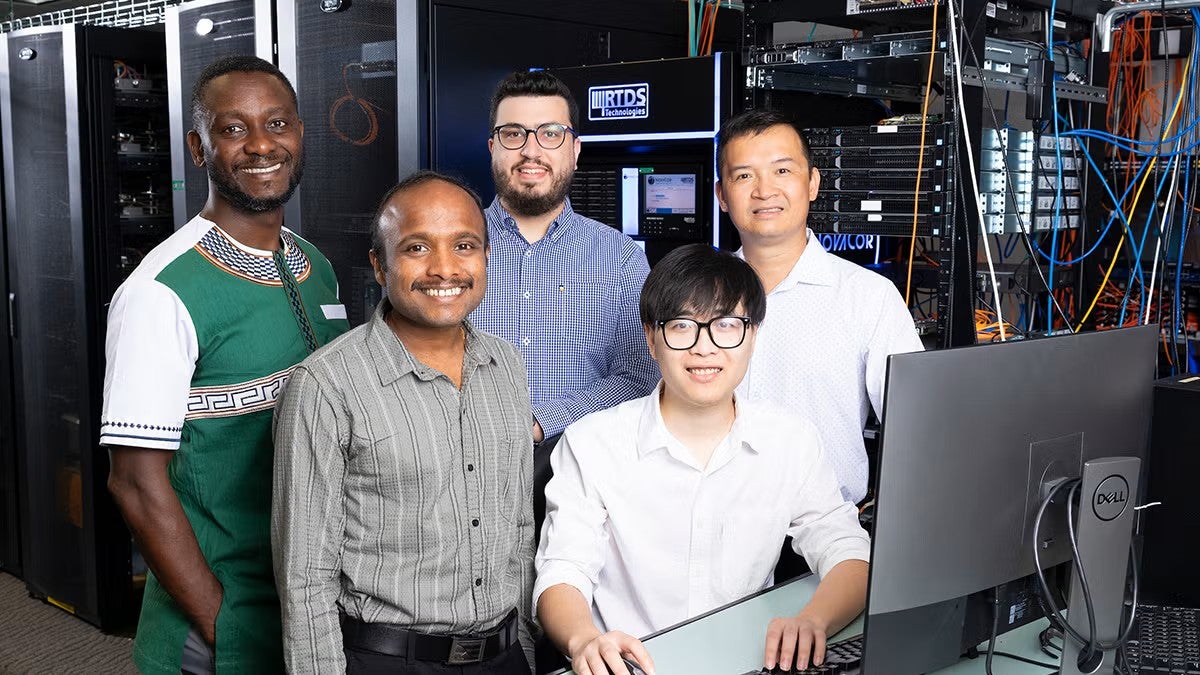 The Cyber-Physical Systems Security Group members by a computer.