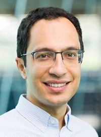 photo of man with glasses smiling in light blue button-up shirt