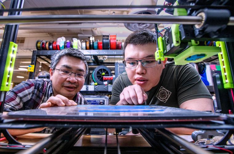 Hui Wang and graduate student watching 3D printer