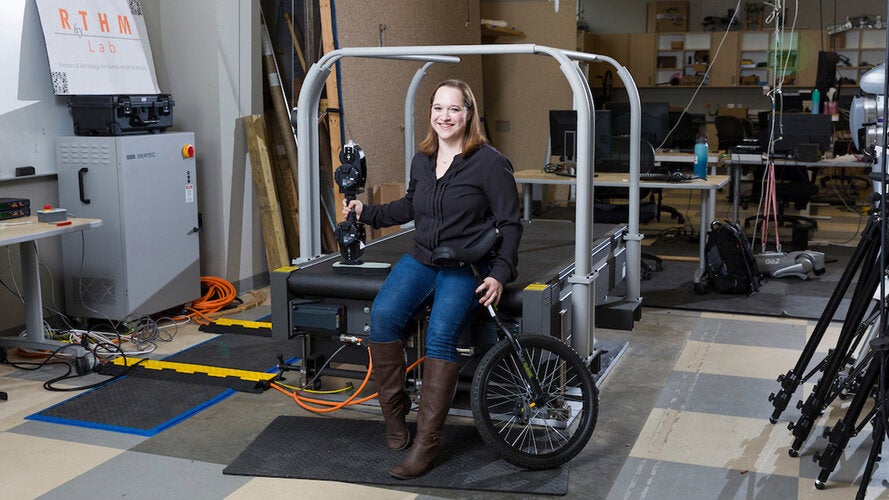 Taylor Higgins, Ph.D., assistant professor of Mechanical Engineering, poses with a unicycle and the Open Source Leg (developed by the University of Michigan and sold by Humotech) in the Center for Intelligent Systems Control and Robotics (CISCOR) lab in the Aero-Propulsion, Mechatronics & Energy (AME) building of FAMU-FSU College of Engineering in Tallahassee, Florida on December 10, 2024.