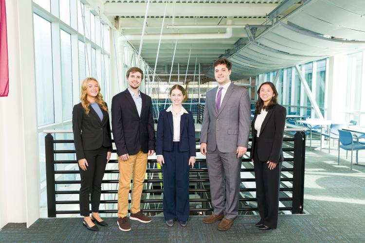 The four members of engineering senior design team 405 stand together on the third floor breezeway at the FAMU-FSU College of Engineering.