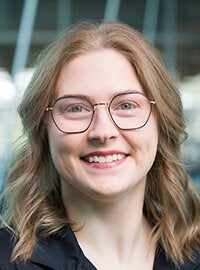 headshot of woman with glasses and blonde hair in black shirt