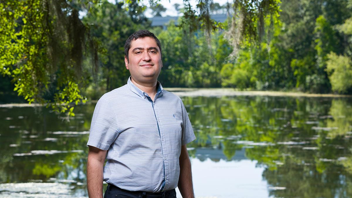 photo of professor ebrahim ahmadisharaf in front of a pond