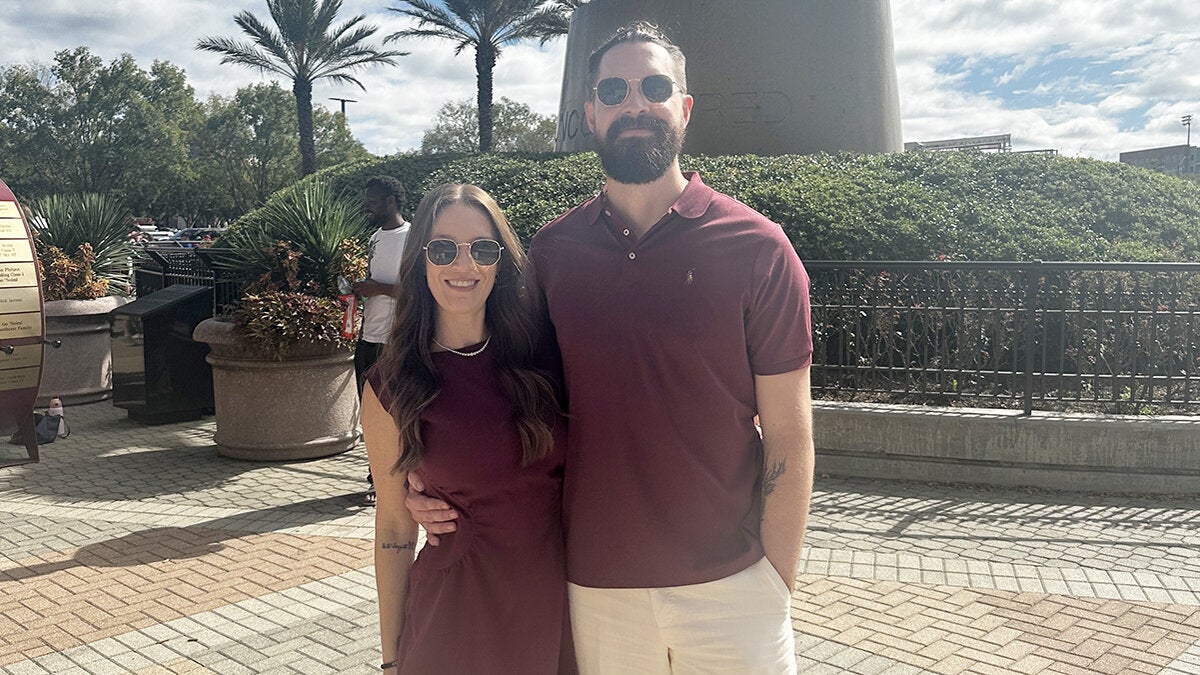 photo of couple wearing sunglasses outside embracing