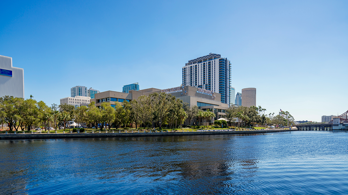 downtown buildings photo with river in front and blue sky