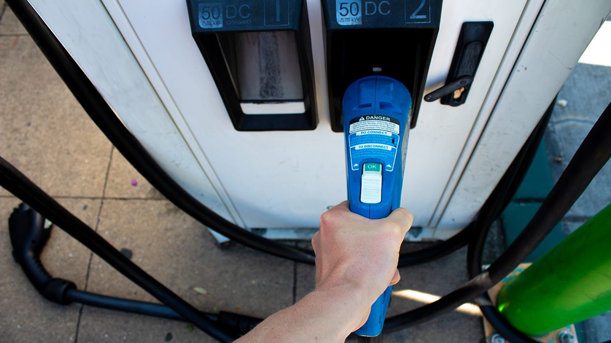 photo of hand on ev charging handle