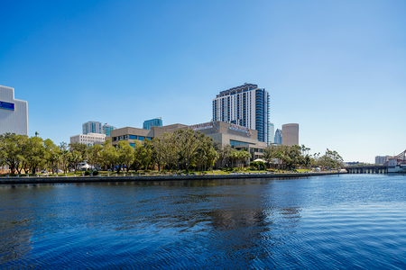 downtown buildings photo with river in front and blue sky