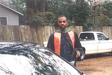 man in graduation regalia in front of car old image