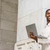 college student in white jacket with laptop