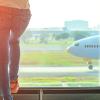 photo of woman watching airliner on runway