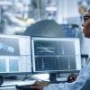 photo of black aerospace engineer at computer looking at satellite design