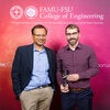 Two individuals pose in front of a FAMU-FSU College of Engineering backdrop, with the person on the right holding a clear glass award.