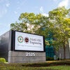 photo of the famu-fsu engineering sign against trees and building and blue sky