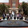 group of people standing in front of building, fountain with words Florida State University in front of them