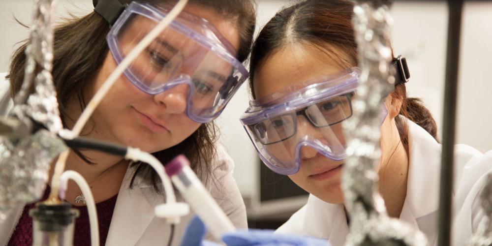 Two female graduate students looking at an experment