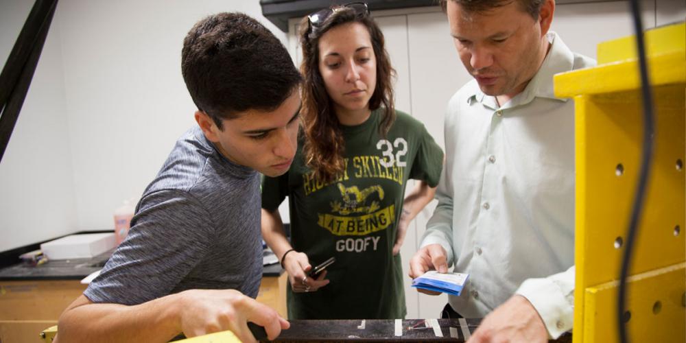 Dr. Kampmann with two undergraduate students in a civil lab