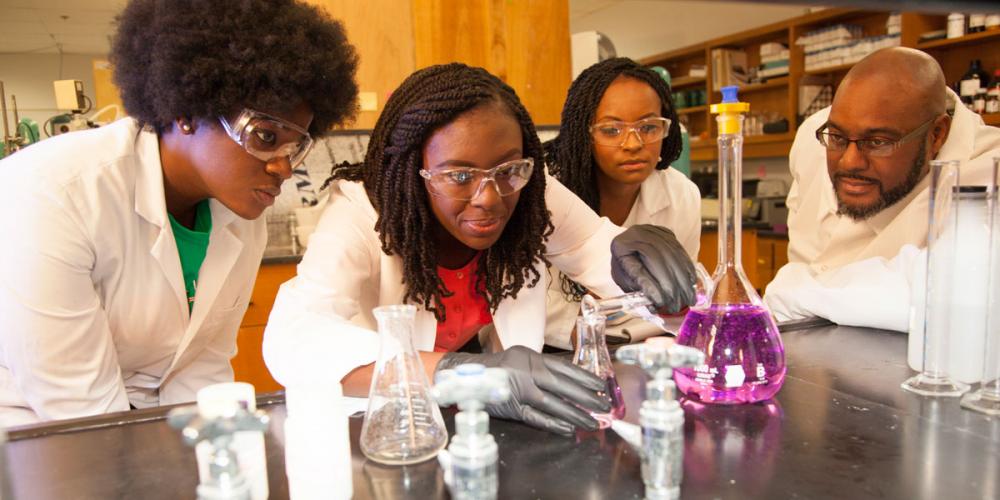 Dr. Clayton Clark with three graduate students