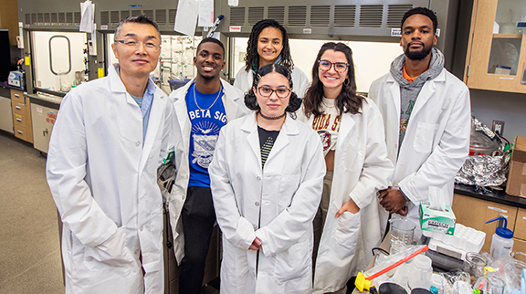 photo of civil engineering professor gang chen in the lab with his students