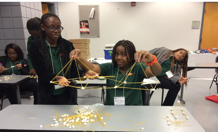 Students from FAMU DRS building a spaghetti bridge