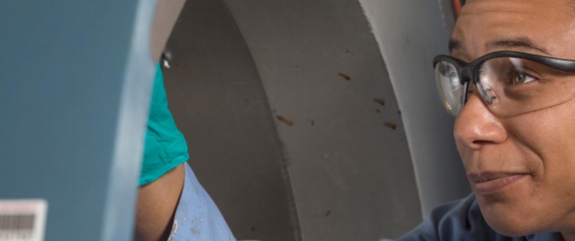 Graduate female researcher inspects internal components of a tunnel