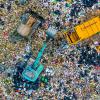 Aerial view of landfill with dump trucks and crane