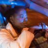 black woman in car at night with emergency lights