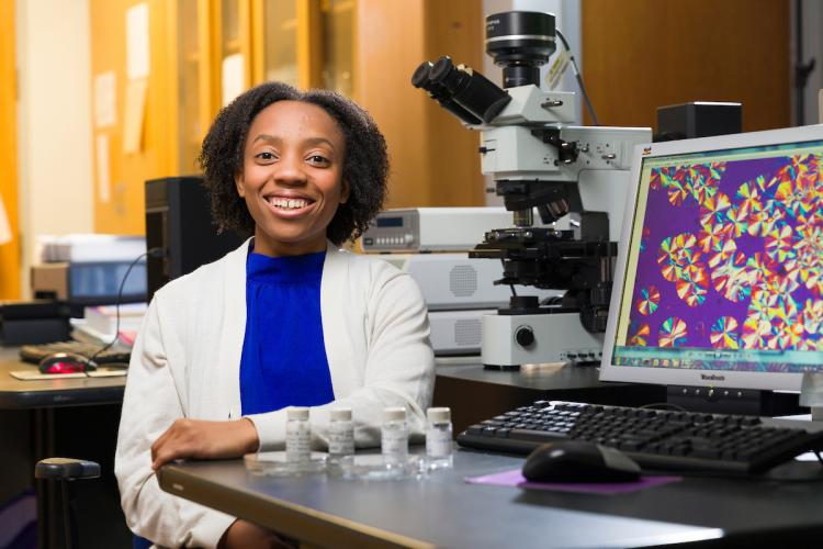 Briona Carswell poses with an on-screen microscopic image of her polymers as well as some samples in the Alamo Lab at FAMU-FSU College of Engineering in Tallahassee, Florida on October 25, 2024.