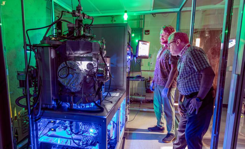 Anbdre Juliao, left, a 4th year Grad student working on his Ph.D. and Lance Cooley, Ph.D., a Professor of Mechanical Engineering and Director, Applied Superconductivity Center (ASC) observing a thin-film deposition of niobium for high-field cavities for Axion dark matter detection.