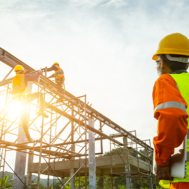 Construction manager observing two workers on a project in the air