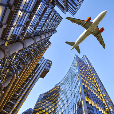 Commercial airplane flying over downtown city buildings