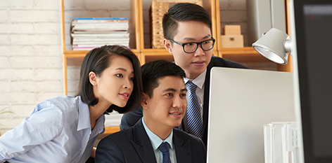 Three people looking at a computer screen together