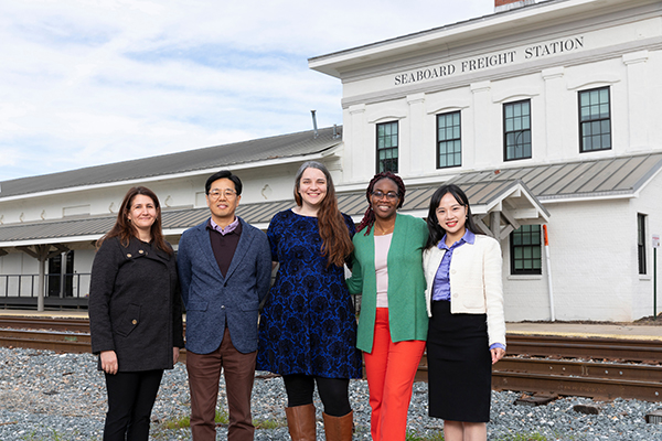 photo of group of researchers in front of historic train station