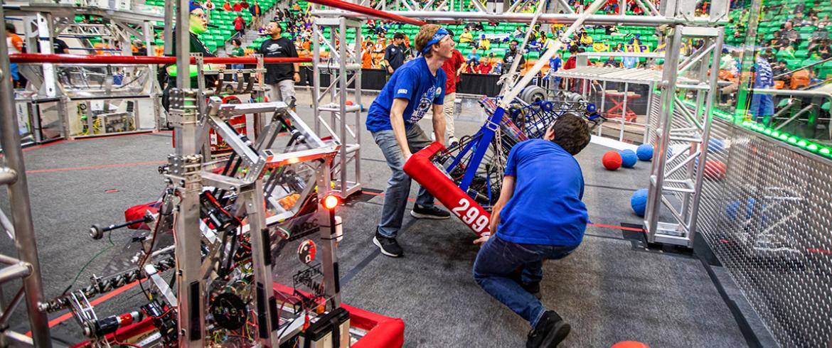 photo of high school students with FIRST robotics robot