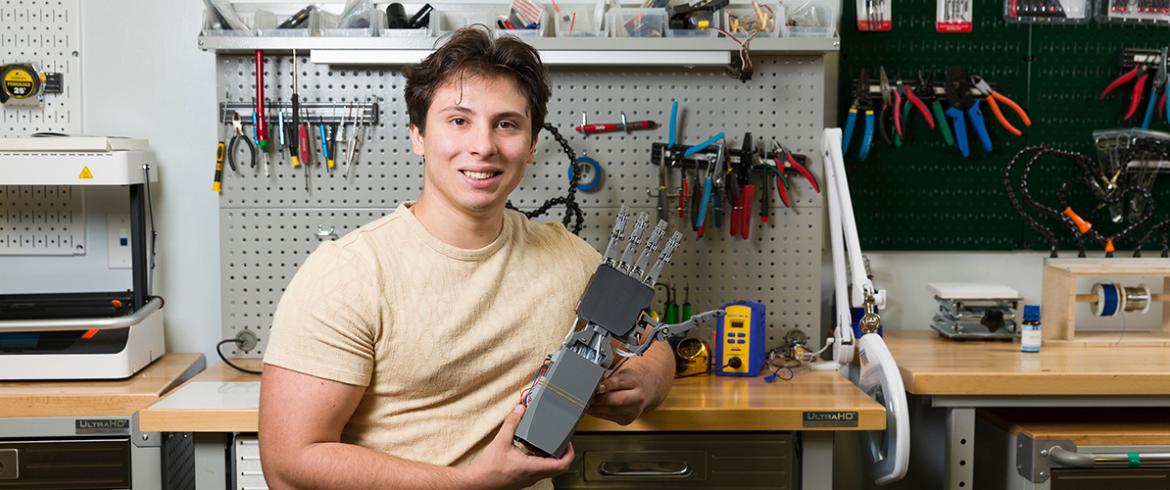 photo Nikolya Cadavid poses with his AI-powered prosthetic hand prototype at FAMU-FSU College of Engineering in Tallahassee, Florida