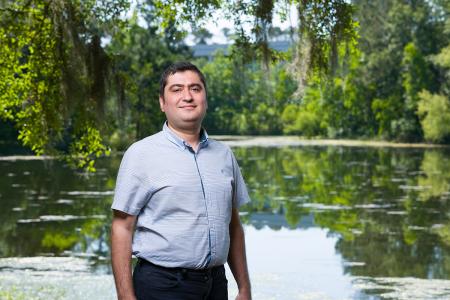photo of professor ebrahim ahmadisharaf in front of a pond