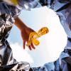 photo of hand dropping banana peel into a trash can