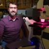photograph of famu-fsu engineering professor tristan driscoll at a microscope in his lab